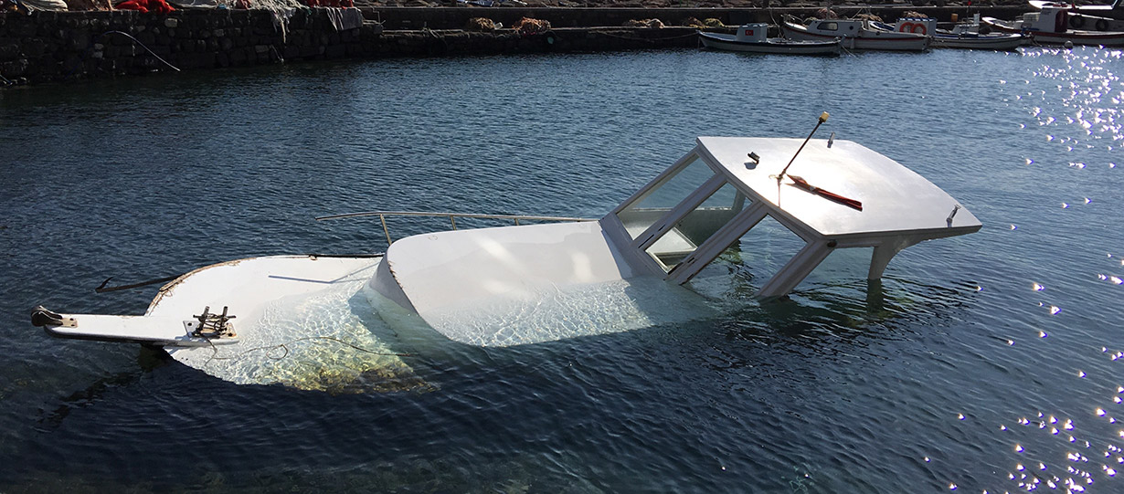 A boat sits mostly submerged after a boating accident.