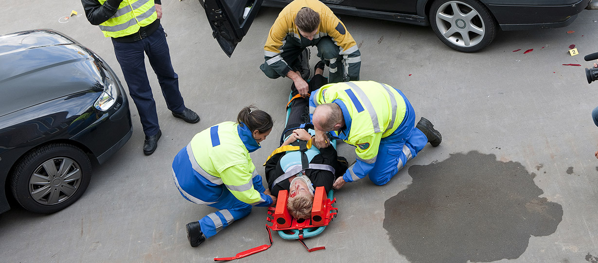 A women injured in a car accident is placed onto a stretcher by paramedics.